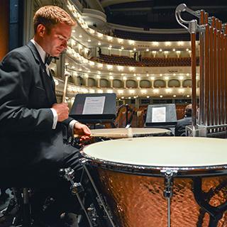 A male TCU music student in a tuxedo rehearses percussion at Fort Worth's Bass Performance Hall